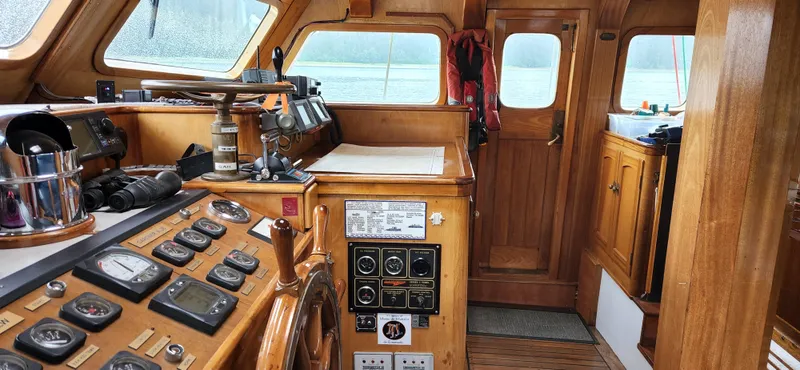 Slide: The Image of 1983 Thackwray Custom Pilothouse Motorsailer interior with wooden helm and navigation instruments. - 6