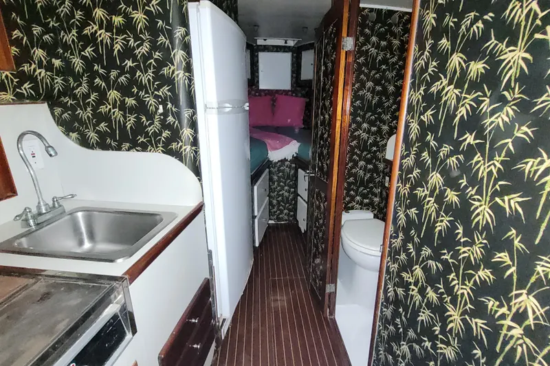 Slide: The Image of Interior of 1984 Sunny Briggs 37 Express boat with bamboo-patterned walls and compact amenities. - 10