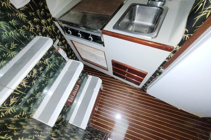 Slide: The Image of 1984 Sunny Briggs 37 Express yacht interior with compact kitchen and patterned walls. - 11