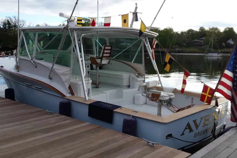 Slide: The Image of 1984 Sunny Briggs 37 Express boat docked, adorned with nautical flags and American flag. - 17