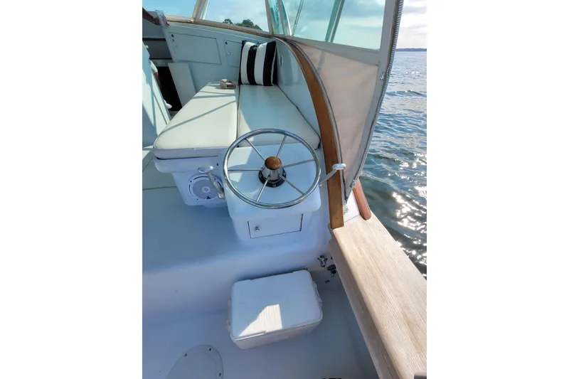 Slide: The Image of 1984 Sunny Briggs 37 Express boat interior with steering wheel and cushioned seating. - 6
