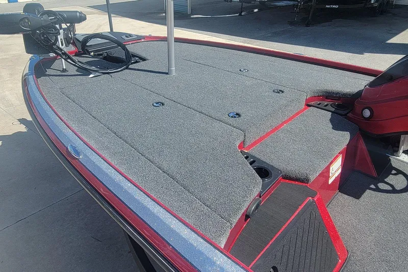 Slide: The Image of 2026 Nitro Z18 boat deck with carpeted surface and fishing equipment. - 10