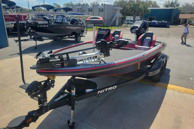 Slide: The Image of 2026 Nitro Z18 boat with trailer, parked outdoors, featuring red and black design. - 6