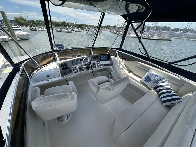 Slide: The Image of 2002 Regal 3880 yacht cockpit with plush seating and marina view. - 10