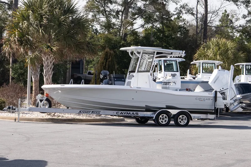 The Image of 2026 Caymas 26 HB boat on trailer, parked outdoors near palm trees. - 1