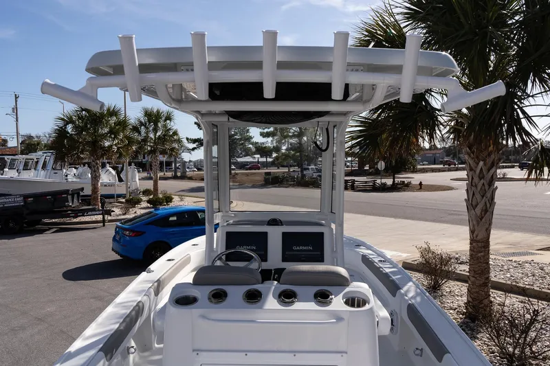 Slide: The Image of 2026 Caymas 26 HB boat with T-top and Garmin electronics, parked near palm trees. - 10