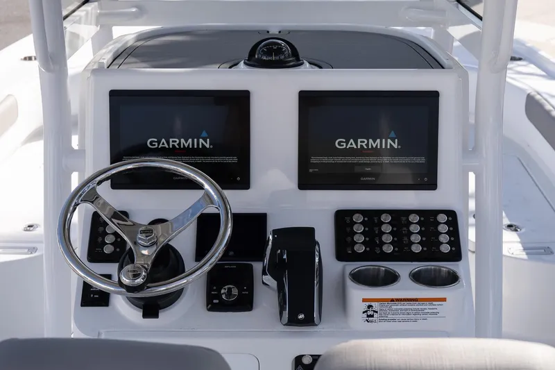 Slide: The Image of 2026 Caymas 26 HB boat dashboard with dual Garmin displays and steering wheel. - 11