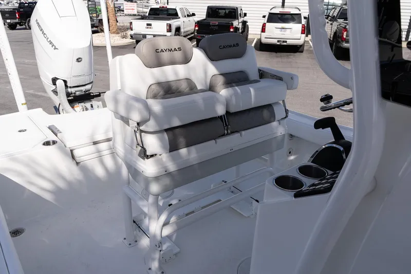 Slide: The Image of 2026 Caymas 26 HB boat interior with dual seats and Mercury engine in a showroom. - 13