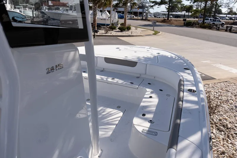 Slide: The Image of 2026 Caymas 26 HB boat deck with seating, parked outdoors in a marina setting. - 14