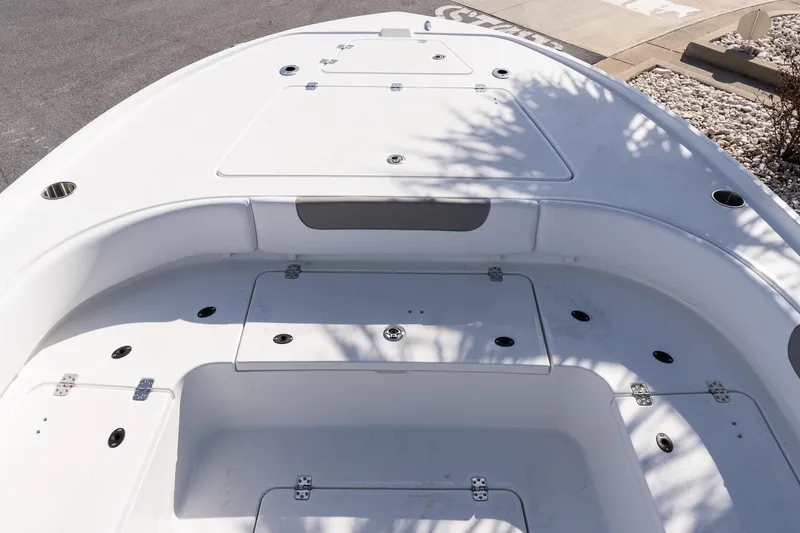Slide: The Image of 2026 Caymas 26 HB boat deck with storage compartments and rod holders. - 16