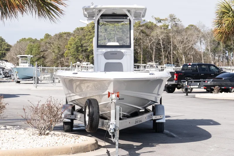 Slide: The Image of 2026 Caymas 26 HB boat on trailer in a parking lot, surrounded by trees. - 3