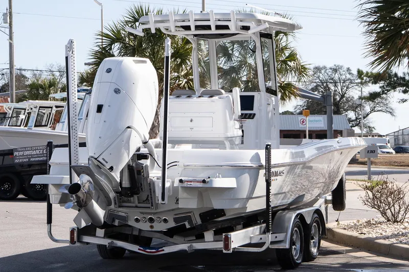 Slide: The Image of 2026 Caymas 26 HB boat on trailer, featuring powerful outboard motor, parked outdoors. - 6