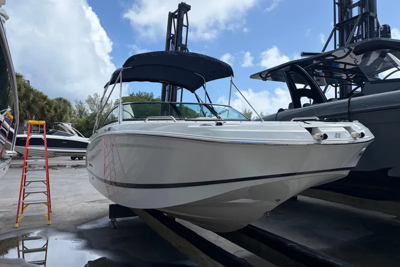 The Image of Four Winns HD3 boat on a lift, with a blue canopy and nearby ladder. - 1
