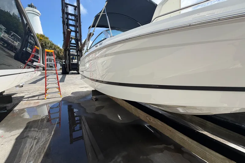 Slide: The Image of Four Winns HD3 boat on dock with ladder and forklift nearby. - 3