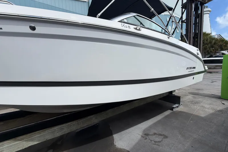 Slide: The Image of Four Winns HD3 boat on a dock, showcasing sleek white hull design. - 5