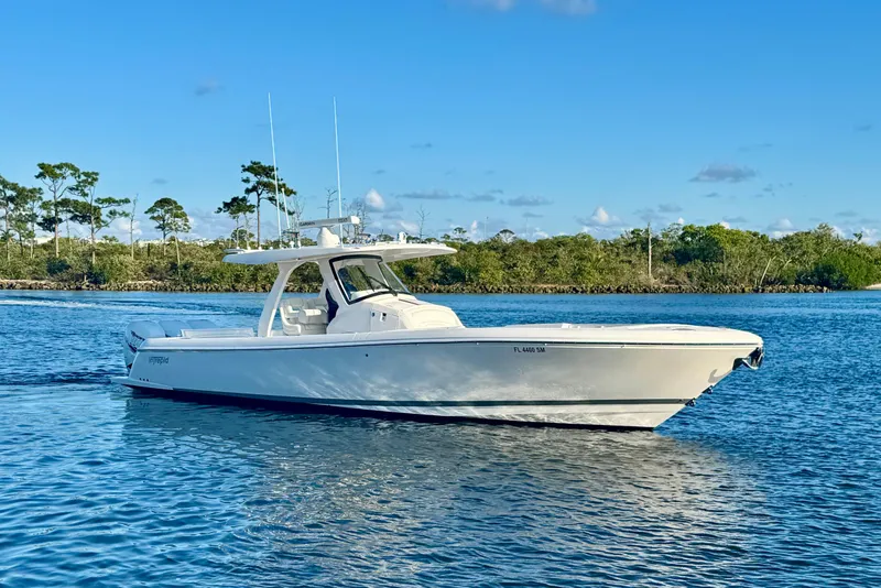 Slide: The Image of 2020 Intrepid 375 Nomad SE boat cruising on a calm, scenic waterway. - 1
