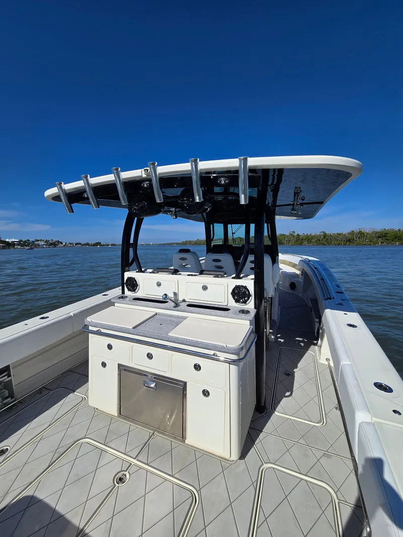 Slide: The Image of HCB 42 Siesta 2018 boat on calm water, blue sky. - 12