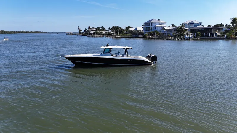 Slide: The Image of 2018 HCB 42 Siesta boat on calm water near coastal homes. - 37
