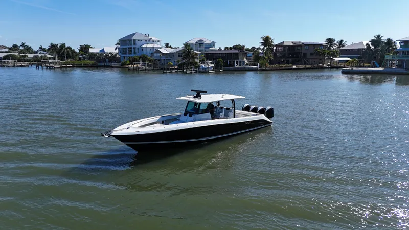 Slide: The Image of 2018 HCB 42 Siesta boat on calm water near coastal homes. - 38