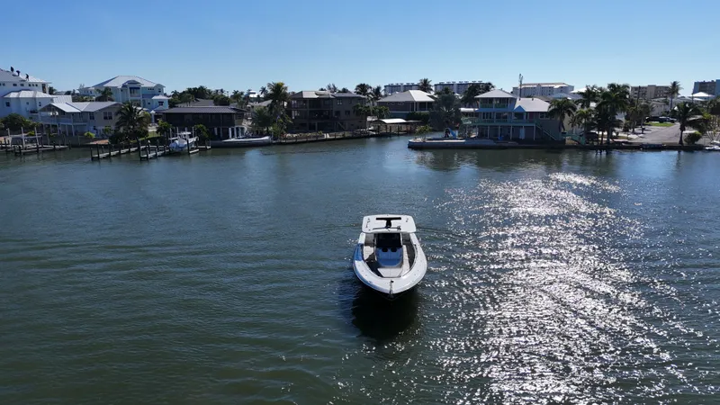 Slide: The Image of HCB 42 Siesta 2018 boat on sunny water near coastal homes. - 39