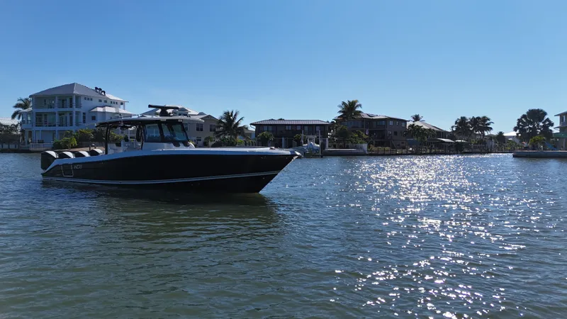 Slide: The Image of HCB 42 Siesta 2018 boat on sunny water near coastal homes. - 43