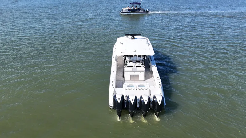 Slide: The Image of HCB 42 Siesta 2018 on calm water with motorboat in background. - 48