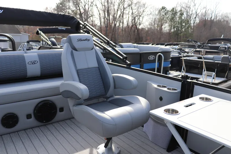 Slide: The Image of 2026 Bentley Pontoons Elite 223 SwingBack DC interior with luxurious seating and table setup. - 6