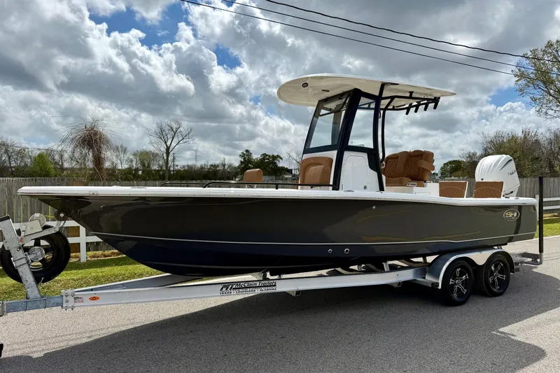 The Image of 2026 Sea Hunt BX 25 FS boat on trailer, parked outdoors under cloudy sky. - 1
