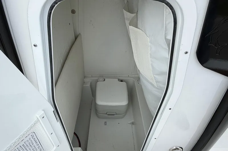 Slide: The Image of Interior view of 2026 Sea Hunt BX 25 FS boat compartment with portable toilet. - 14