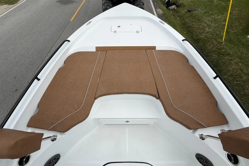 Slide: The Image of 2026 Sea Hunt BX 25 FS boat deck with brown cushioned seating, parked on roadside. - 15