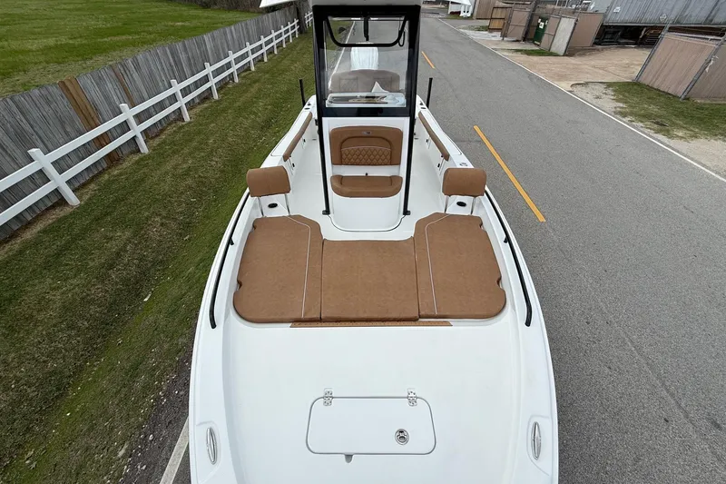 Slide: The Image of 2026 Sea Hunt BX 25 FS boat with brown seating, parked on a road. - 17