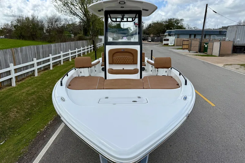Slide: The Image of 2026 Sea Hunt BX 25 FS boat with tan seating, parked on a road. - 6