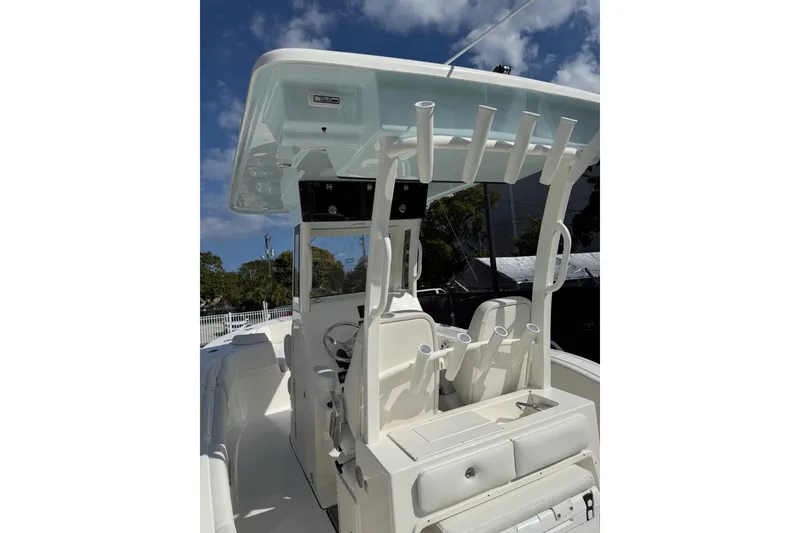Slide: The Image of 2026 Key West 263 FS boat interior with seating and rod holders under a clear sky. - 10