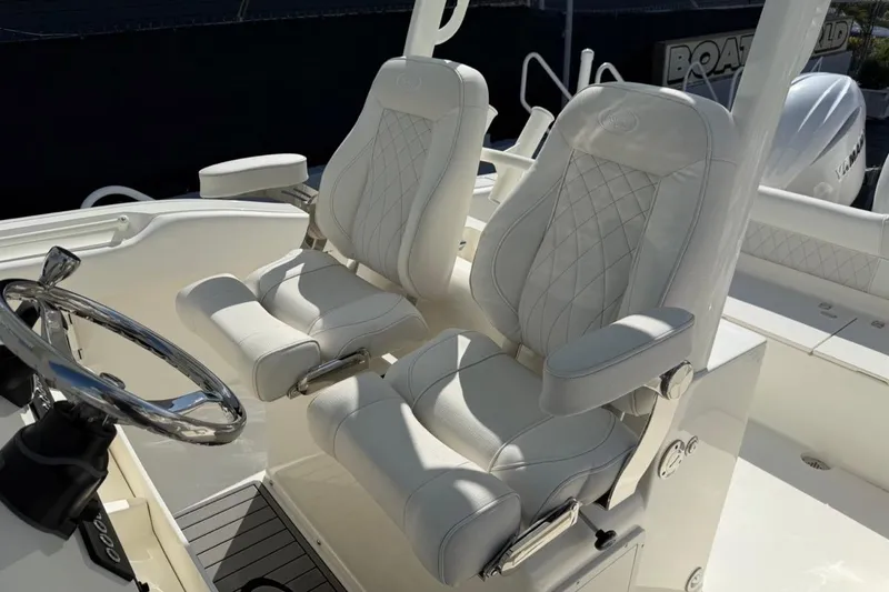 Slide: The Image of 2026 Key West 263 FS boat interior with luxurious white seating and steering wheel. - 11