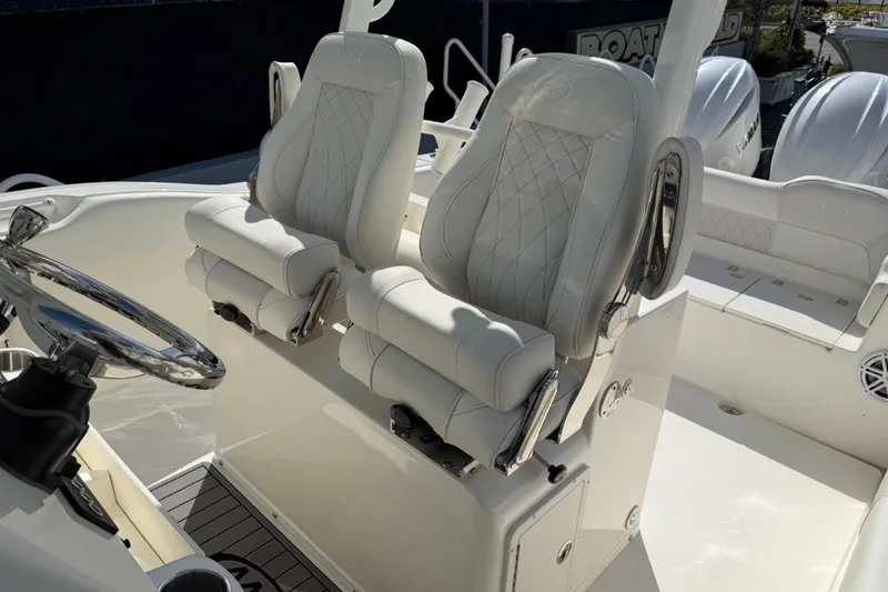 Slide: The Image of 2026 Key West 263 FS boat interior with luxurious white seating and steering wheel. - 12