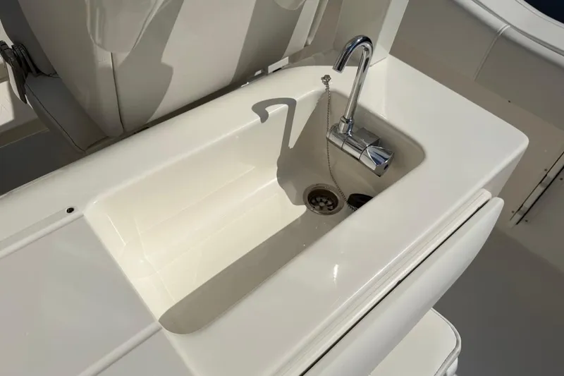Slide: The Image of Key West 263 FS 2026 boat sink with chrome faucet in white interior. - 26