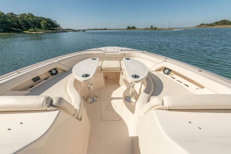 Slide: The Image of 2019 Grady-White Freedom 375 boat interior with seating and tables on calm water. - 30