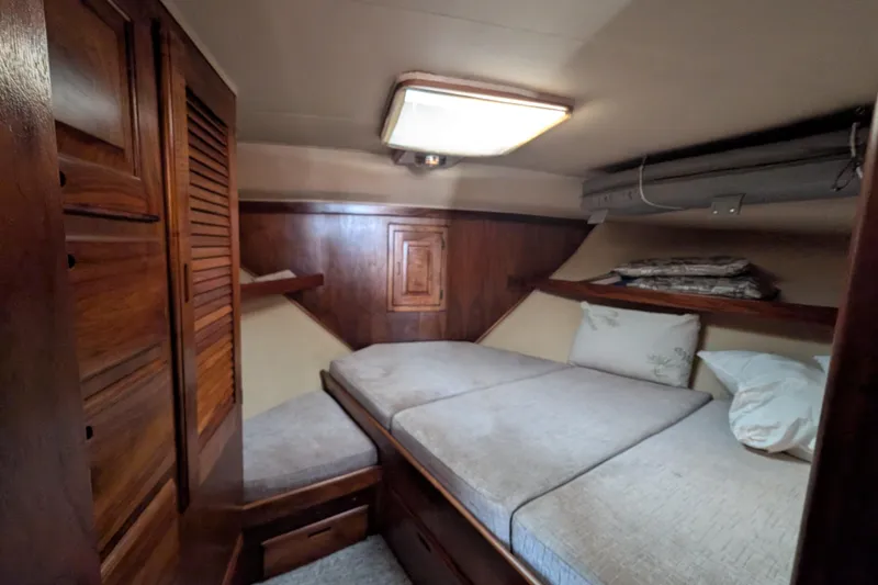 Slide: The Image of Cozy cabin interior of 1984 Californian 38 yacht with wooden furnishings and comfortable bedding. - 10
