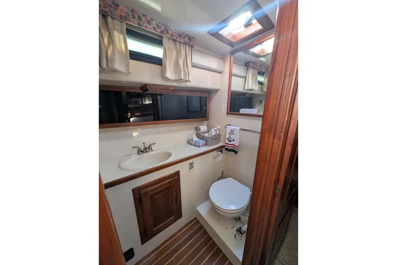 Slide: The Image of 1984 Californian 38 yacht bathroom with sink, toilet, wooden accents, and nautical decor. - 11