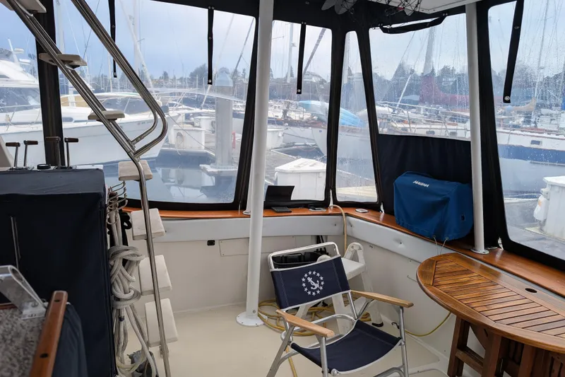 Slide: The Image of 1984 Californian 38 yacht interior with marina view, featuring seating and wooden table. - 19