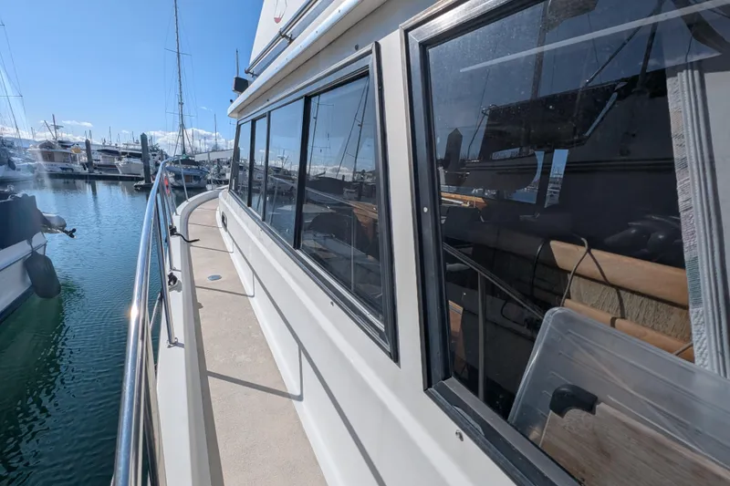 Slide: The Image of 1984 Californian 38 yacht docked at marina, showcasing sleek design and reflective windows. - 22