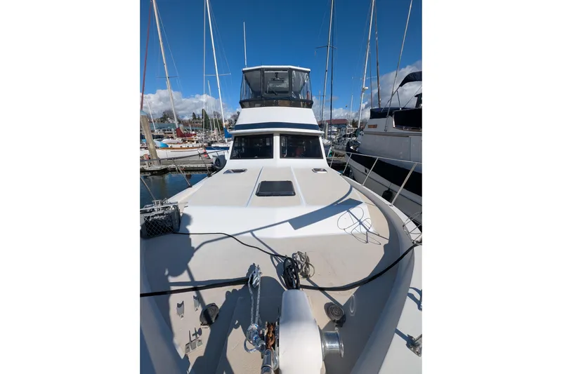 Slide: The Image of 1984 Californian 38 yacht docked at marina, showcasing spacious deck and sleek design. - 26