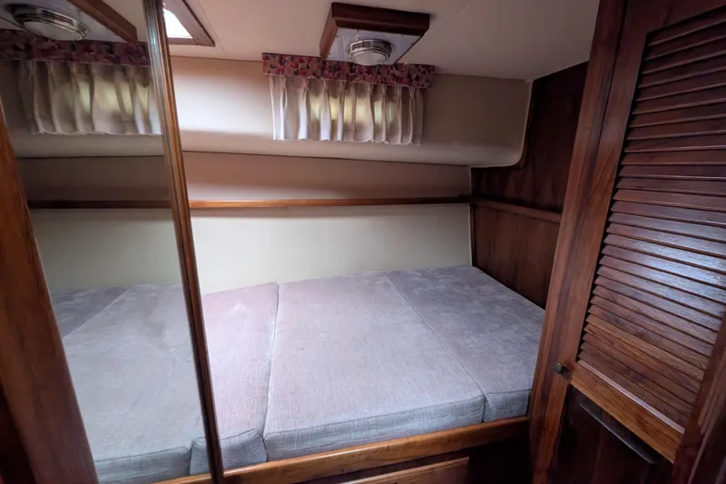 Slide: The Image of Cozy cabin interior of 1984 Californian 38 yacht with wooden accents and comfortable bedding. - 9