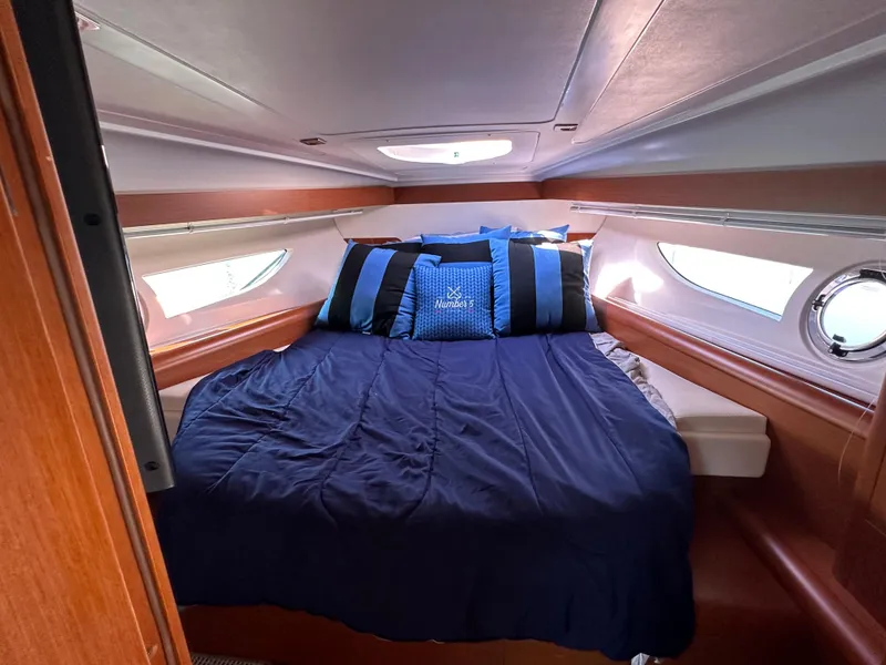 Slide: The Image of Cabin interior of 2013 Beneteau Gran Turismo 38 with cozy bedding and porthole windows. - 12