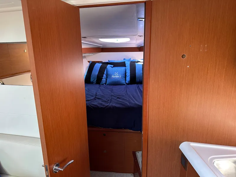 Slide: The Image of Cabin interior of 2013 Beneteau Gran Turismo 38 with cozy bedding and wooden finish. - 13
