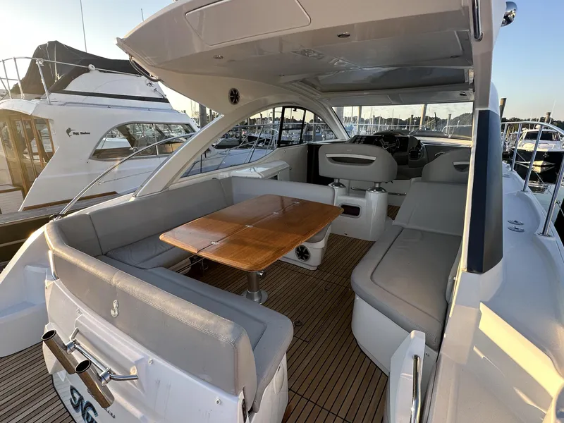 Slide: The Image of 2013 Beneteau Gran Turismo 38 yacht interior with seating and wooden table. - 2