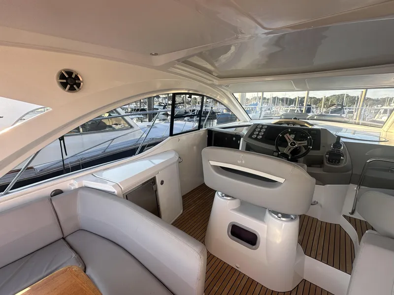 Slide: The Image of 2013 Beneteau Gran Turismo 38 yacht interior with helm, seating, and wood flooring. - 4