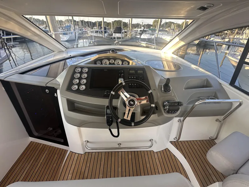 Slide: The Image of 2013 Beneteau Gran Turismo 38 helm with modern controls and wooden flooring. - 7