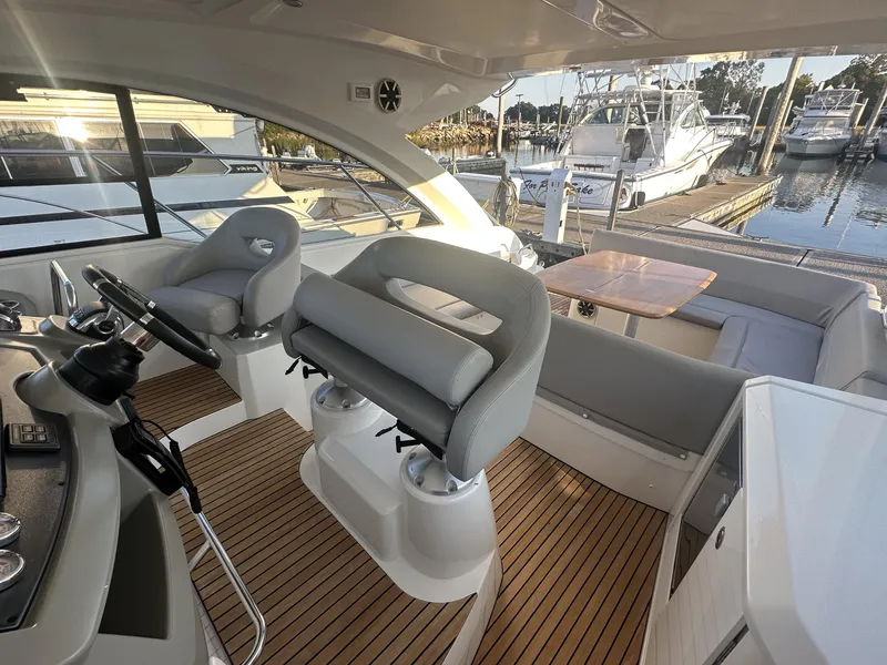 Slide: The Image of 2013 Beneteau Gran Turismo 38 yacht interior with helm, seating, and dock view. - 9