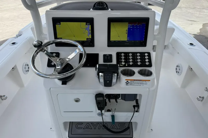 Slide: The Image of 2022 Caymas 28 HB Twin boat dashboard with navigation screens and controls. - 10
